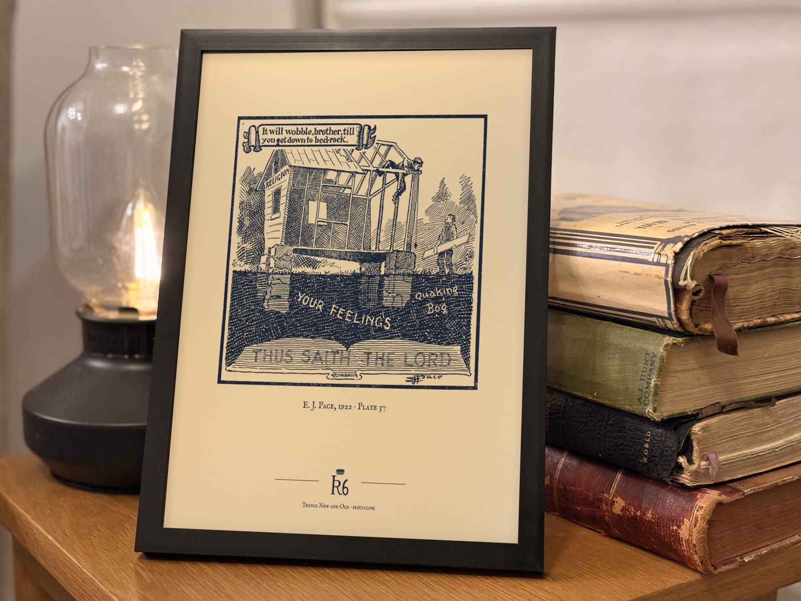 Plate 37 framed in a study, beside a lamp and old books